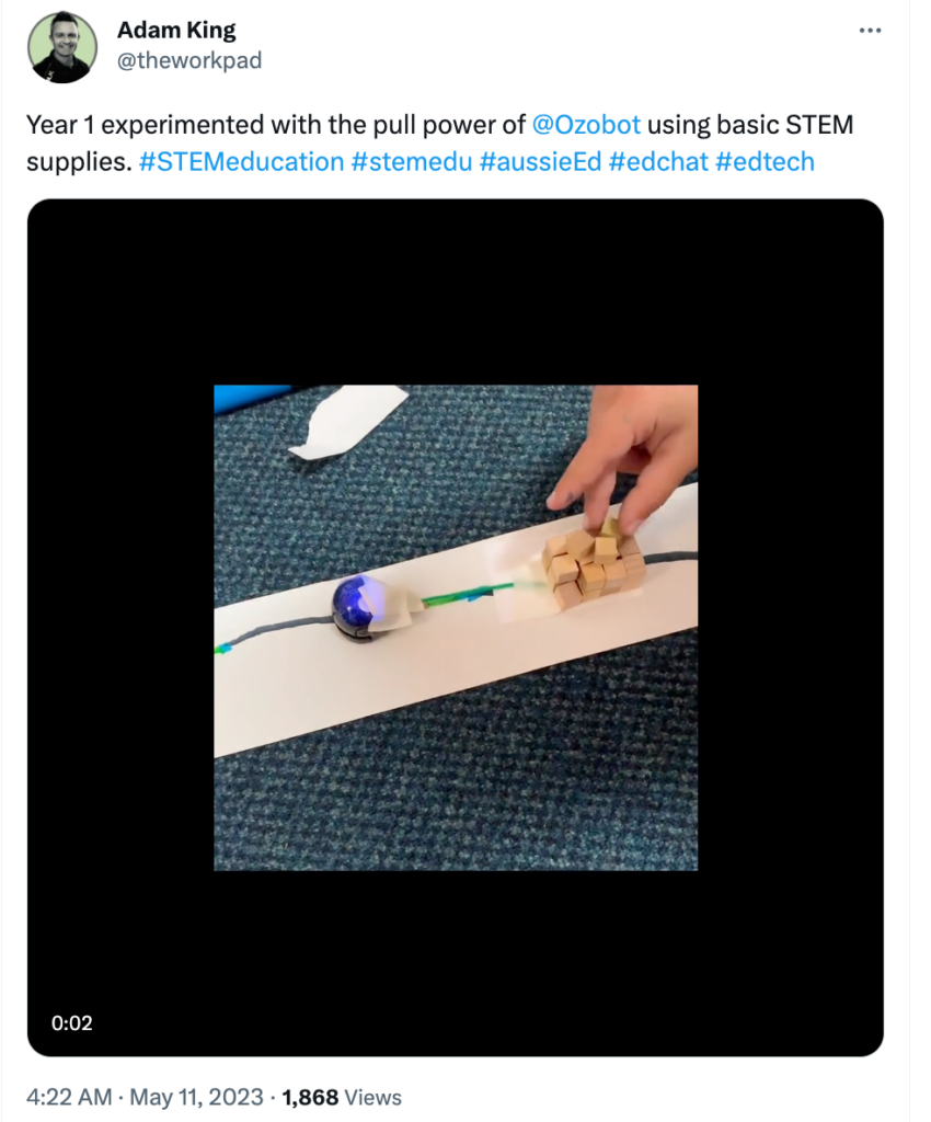 An image showing first grade students build a contraption that stacks blocks with string, tape and paper. 